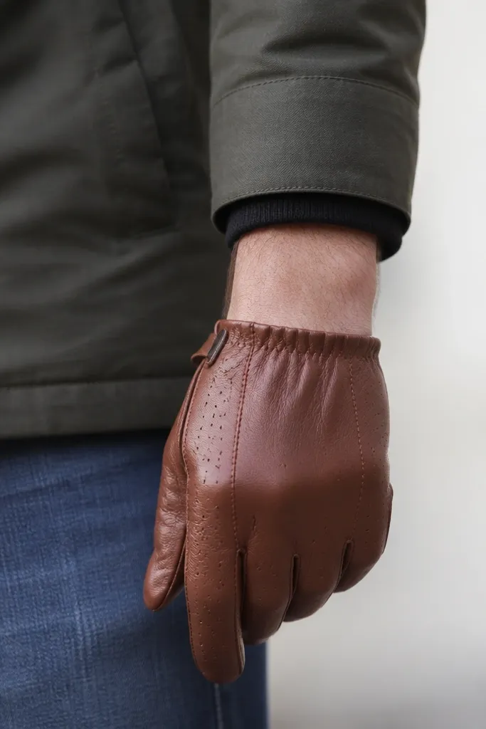 Hand-level photo: a man’s wrist shows a gap between glove cuff and jacket sleeve. The gloves are short and the jacket cuff rides up slightly.